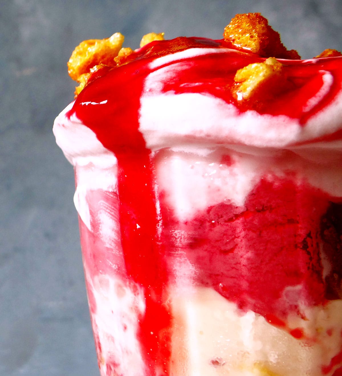 raspberry coulis drizzled on top of knickerbocker glory sundae