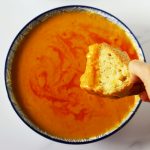 bread dipped into turkish red lentil soup